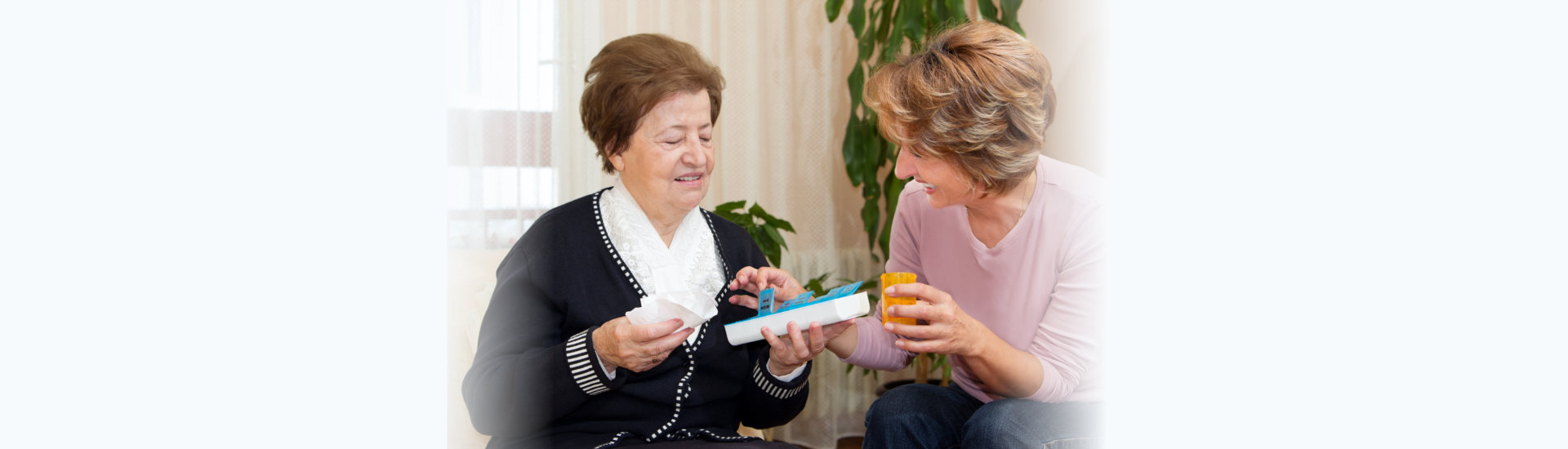 caregiver giving medicine to her patient