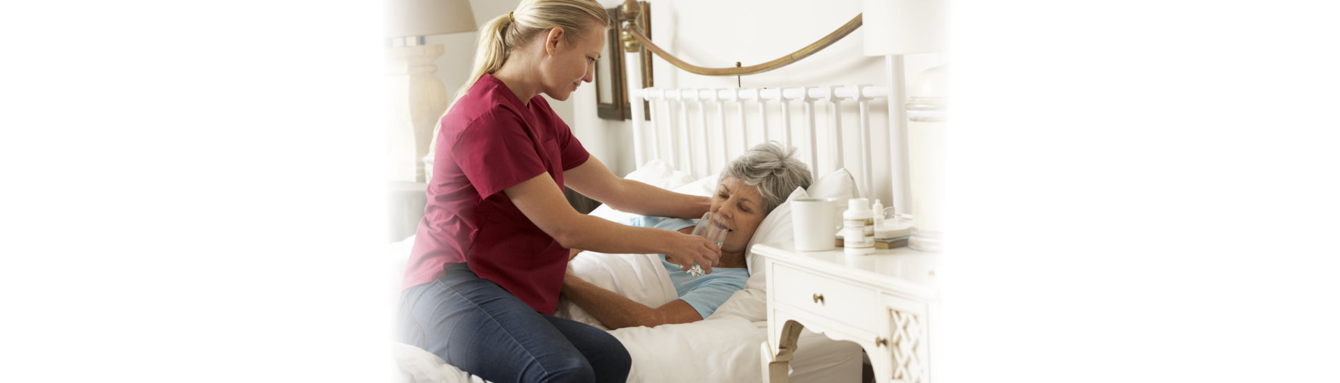 caregiver giving a glass of water to her patient